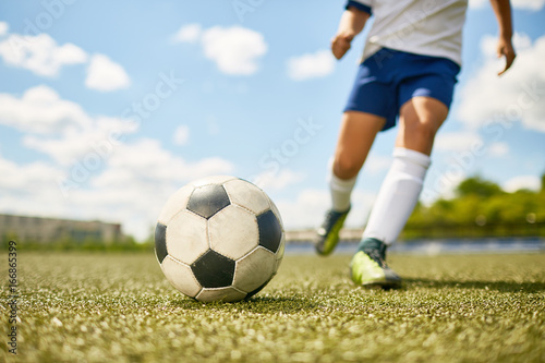 Boy Kicking Ball in Football © Seventyfour