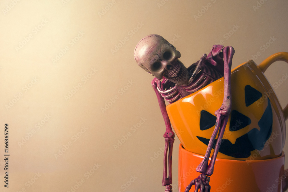 skeleton with halloween pumpkin coffee cup