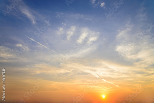 sunset / sun rise sky with rays of yellow and red light shining clouds and sky background and texture © lukyeee_nuttawut