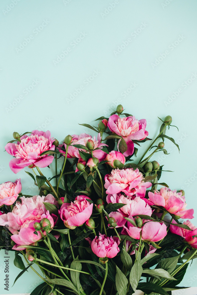 Beautiful pink peonies flowers bouquet on pale blue background. Flat lay, top view flowers pattern.