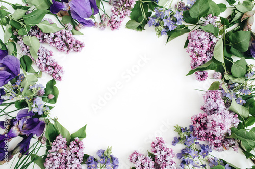 Fototapeta Naklejka Na Ścianę i Meble -  Frame of lilac flowers, branches, leaves and petals with space for text on white background. Flat lay, top view
