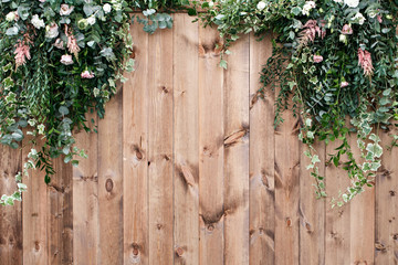 Fresh spring greens with white flower and leaf plant over wood fence background
