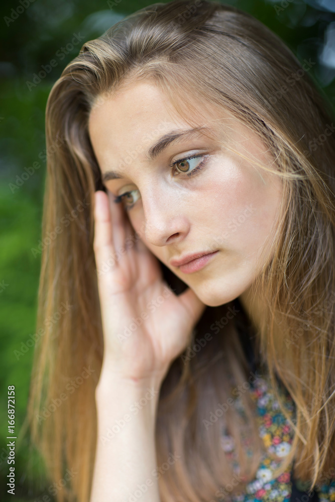Close Up Of Unhappy Teenage Girl Sitting Outdoors Close Up Of Unhappy Teenage Girl Sitting Outdoors