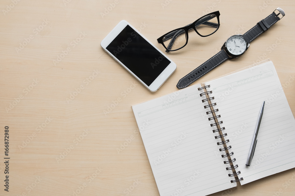 office equipment,laptop computer, smartphone with white screen over a notebook and cup of coffee. Top view with copy space, flat lay. office equipment,laptop computer, smartphone with white screen over a notebook and cup of coffee. Top view with copy space, flat lay.
