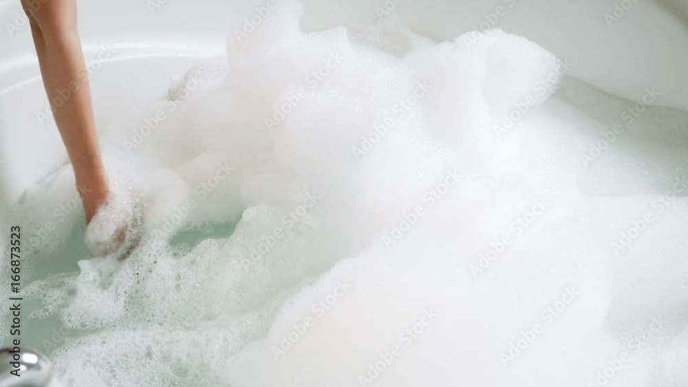 girl touched the foam poured into large round bathroom