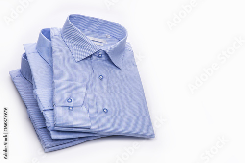 Three blue men's shirts folded in a pack on a white background.