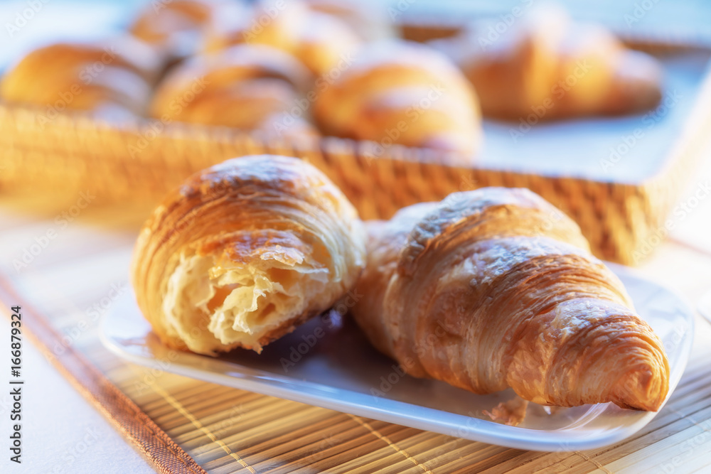 Tasty croissants with spikelets on wooden background; taste of France to the breakfast table.