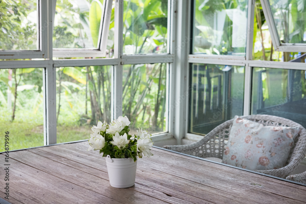 bouquet of white siam tulip flower in vase on wood table near window with garden view. decoration and interior bouquet of white siam tulip flower in vase on wood table near window with garden view. decoration and interior