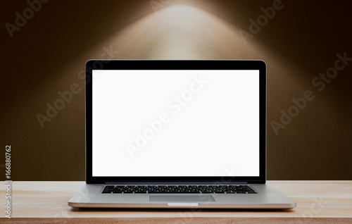 Laptop with blank screen on wood table and down lighht background. Clipping path include.