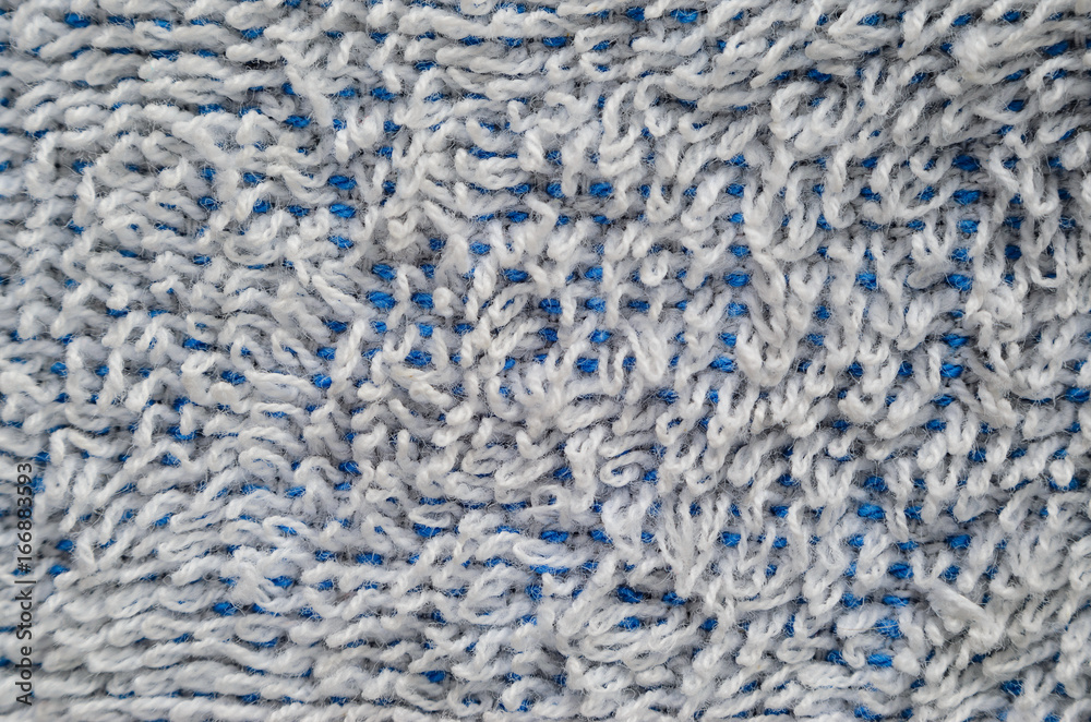 Macro shot of a white towel. Texture is similar to the texture of a fleecy knotted-pile carpet. Chaotically directed white villi on a blue basis Macro shot of a white towel. Texture is similar to the texture of a fleecy knotted-pile carpet. Chaotically directed white villi on a blue basis