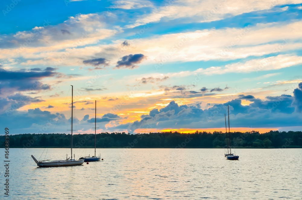Boats on a beautiful lake. Evening summer landscape by the water. Boats on a beautiful lake. Evening summer landscape by the water.
