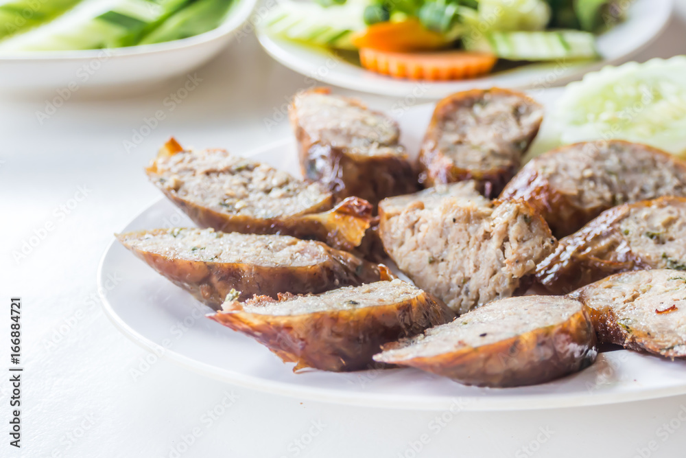 Northern Thai spicy sausage on white dish and table for lunch or dinner.