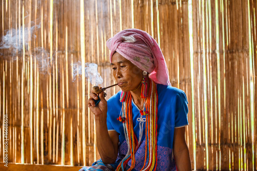 Фотография Female karen hill tribe is smoking tobacco pipe traditional in the cottage of no