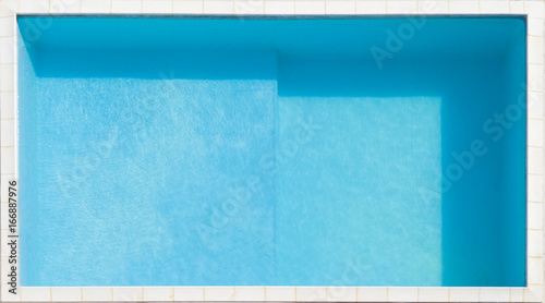 Vista aerea in primo piano di una piscina azzurra piena d'acqua pulita. Intorno a fare da bordo piscina mattonelle di marmo. Nel dettaglio si trata di una piscina privata di piccole dimensioni. photo