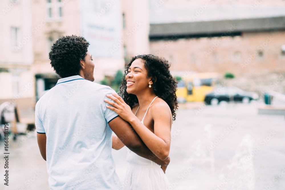 Smiling couple of lovers having fun in european city streets in summer time. Smiling couple of lovers having fun in european city streets in summer time.