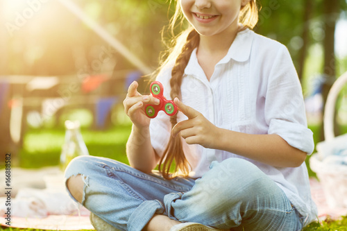 Fotografía Active child having fun with fidget spinner in park