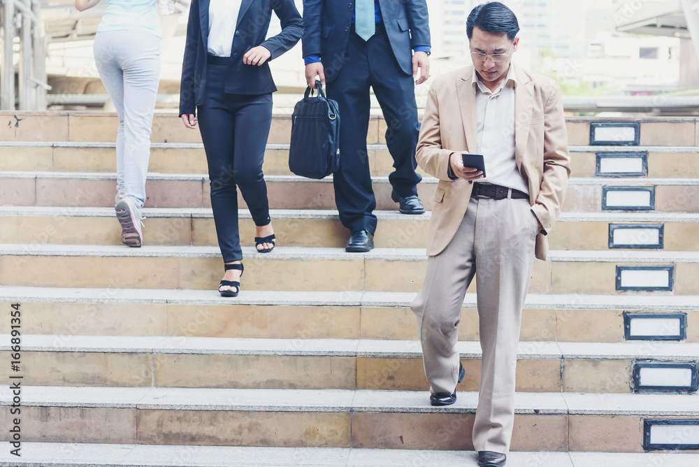 Professional man using smart phone,Businessman holding mobile smartphone using app texting sms message, checking email and social media while walking in the city. Professional man using smart phone,Businessman holding mobile smartphone using app texting sms message, checking email and social media while walking in the city.