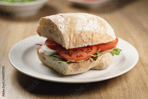 ciabatta sandwich with speck, mozzarella and vegetables