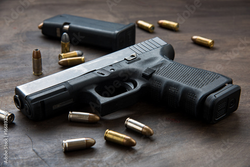Gun with ammunition on dark background. 