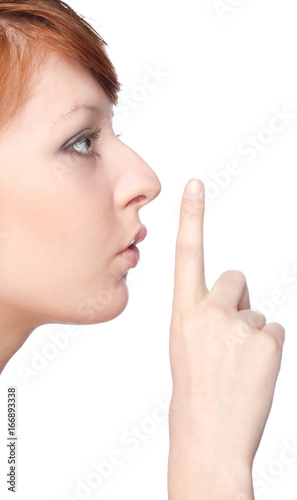 a girl holds a finger to lips gesture silently