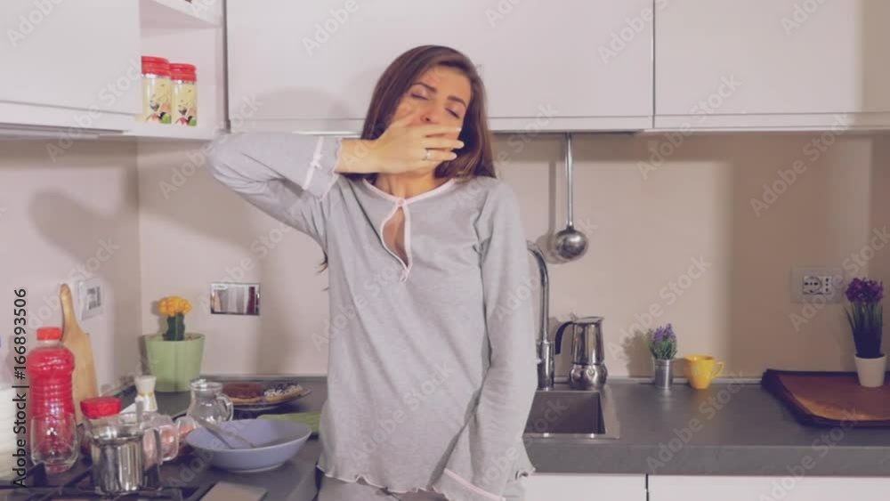 Cute woman tired in the morning yawning and stretching in kitchen slow motion Cute woman tired in the morning yawning and stretching in kitchen slow motion