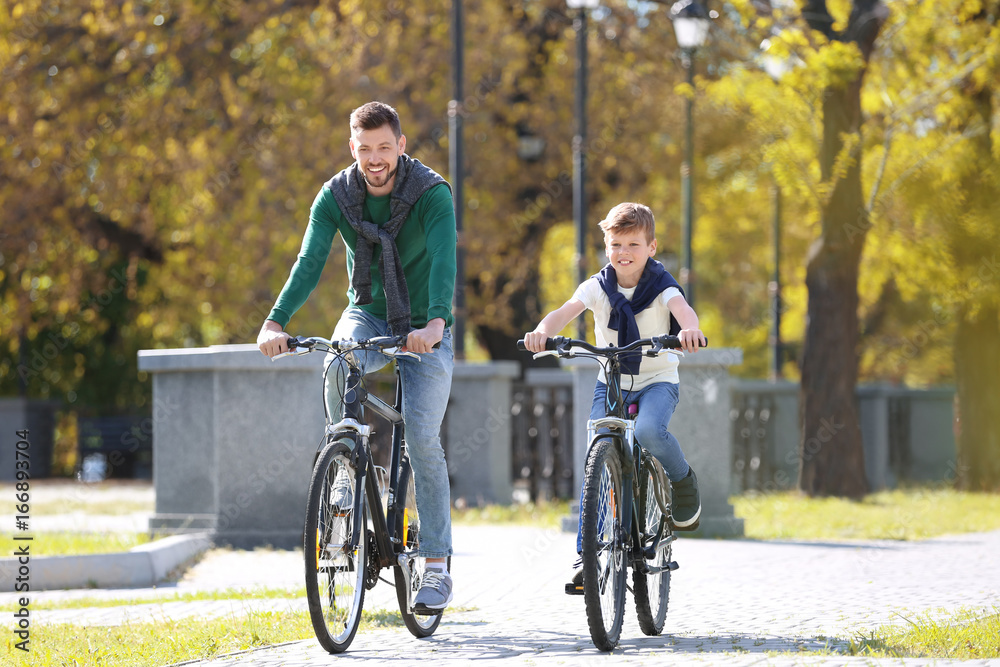 Dad and son riding bicycles outdoors