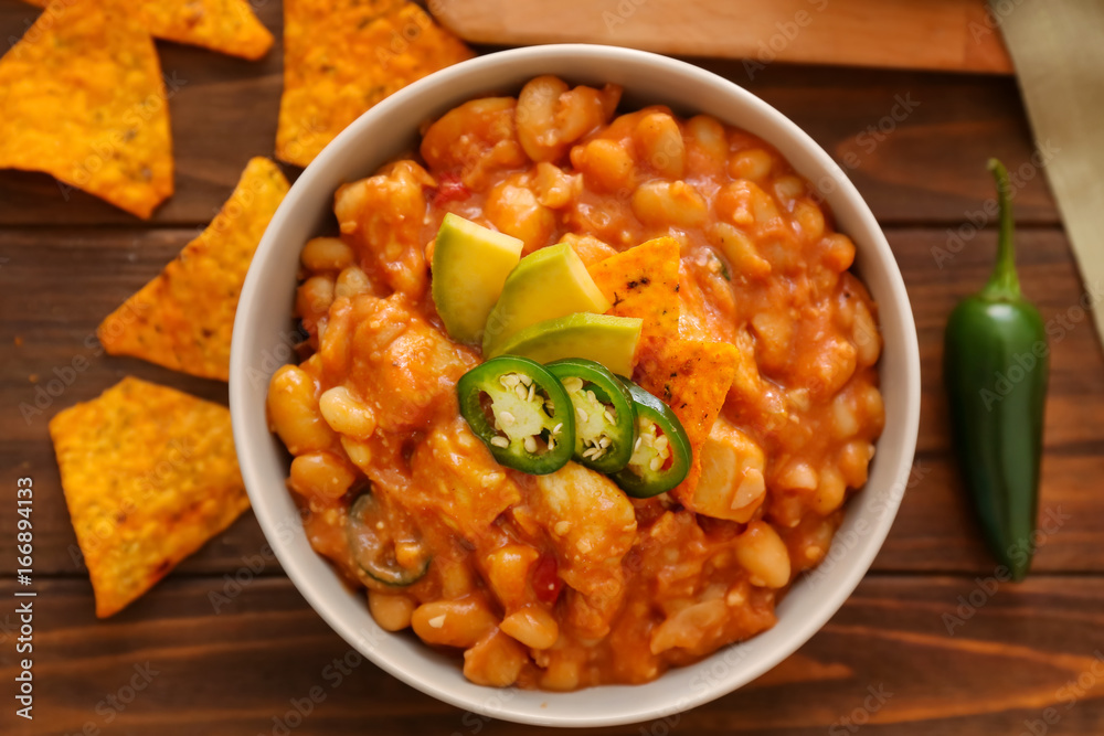 Bowl with delicious turkey chili on wooden background Bowl with delicious turkey chili on wooden background