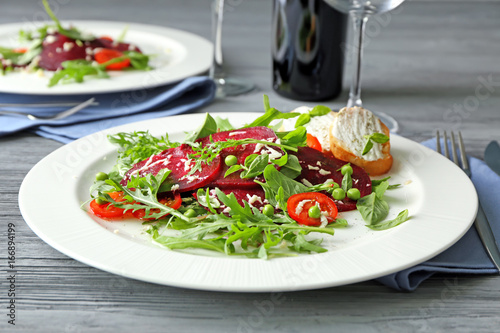 Plate with useful beet salad on table