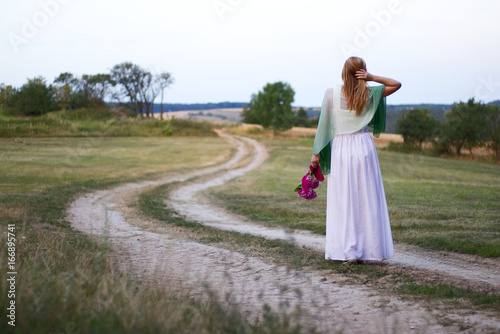 The beautiful bride on a rural footpath