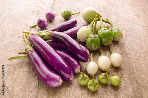 Healthy food round and long fresh organic raw purple and green brinjal or purple eggplant or aubergine on wood table