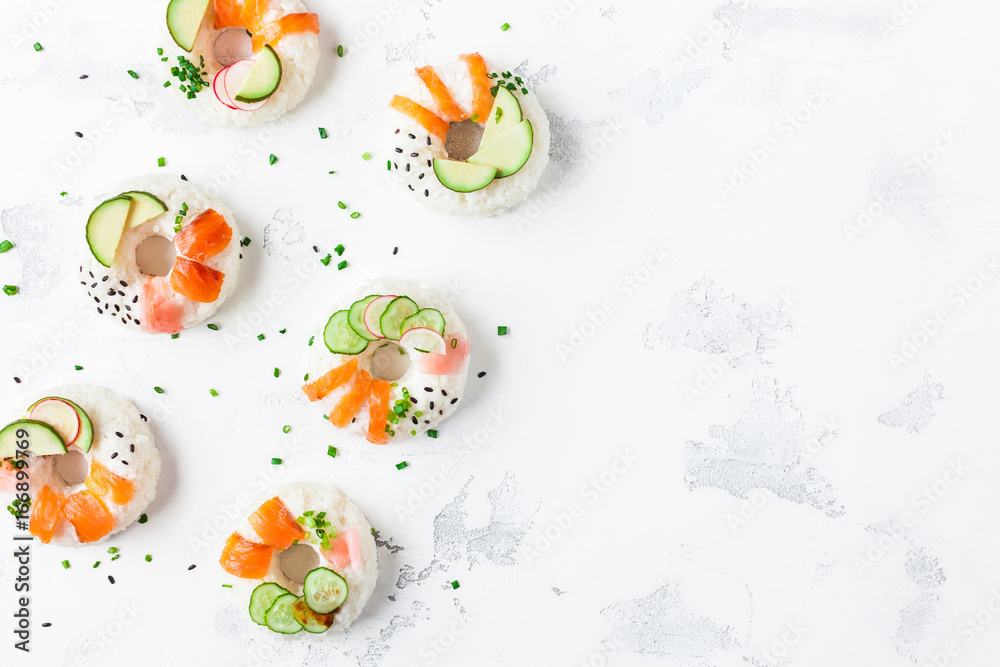 Sushi donuts set on white background. Sushi food trend. Flat lay, top view, copy space Sushi donuts set on white background. Sushi food trend. Flat lay, top view, copy space