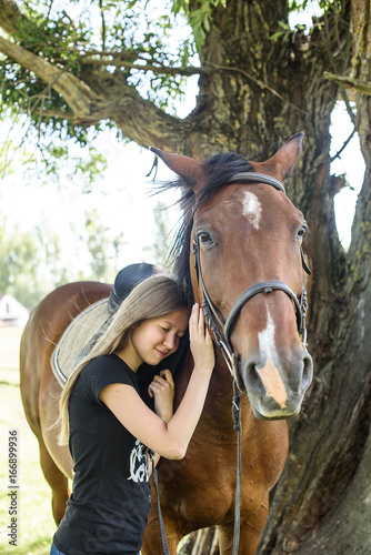 Portrait girl and horse in outdoor. Girl hugging a horse