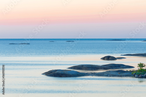 Islets in the archipelago during the sunrise. Red and blue shades