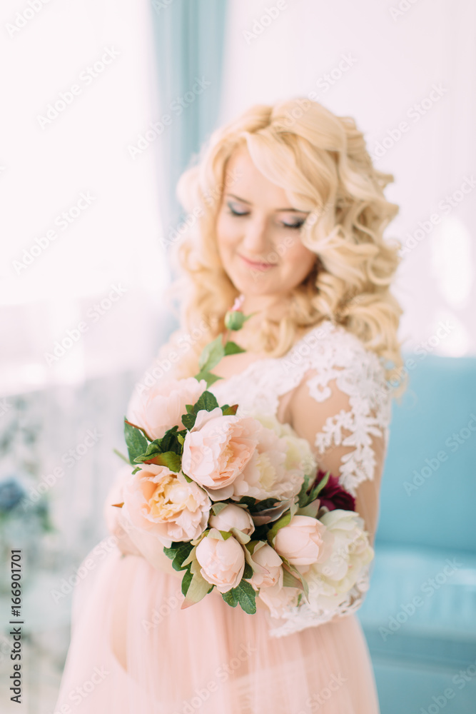 Pregnant young girl in a light orange dress with flowers Pregnant young girl in a light orange dress with flowers