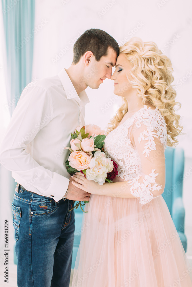 Pregnant young girl in a light orange dress with her husband