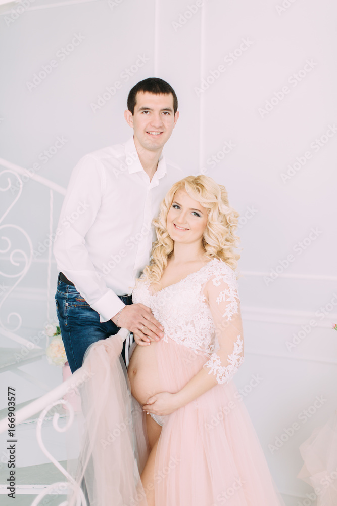Pregnant young girl in a light orange dress with her husband Pregnant young girl in a light orange dress with her husband