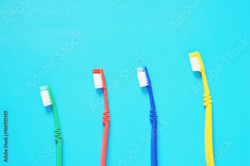 Colorful toothbrushes on a blue background/ Green, red, blue and yellow toothbrushes