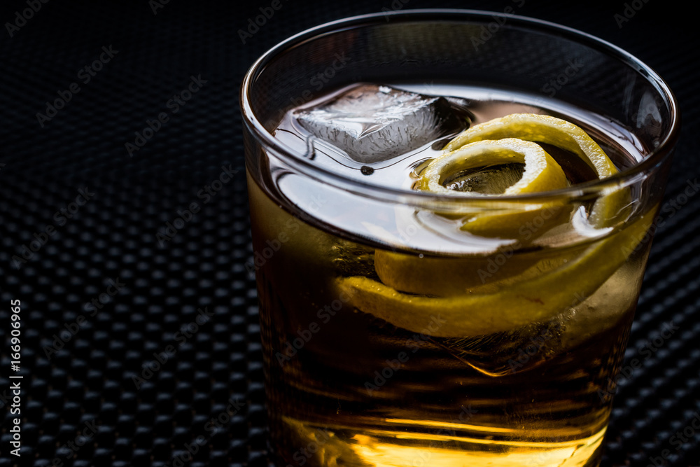 Highball cocktail with lemon peel and ice. Highball cocktail with lemon peel and ice.