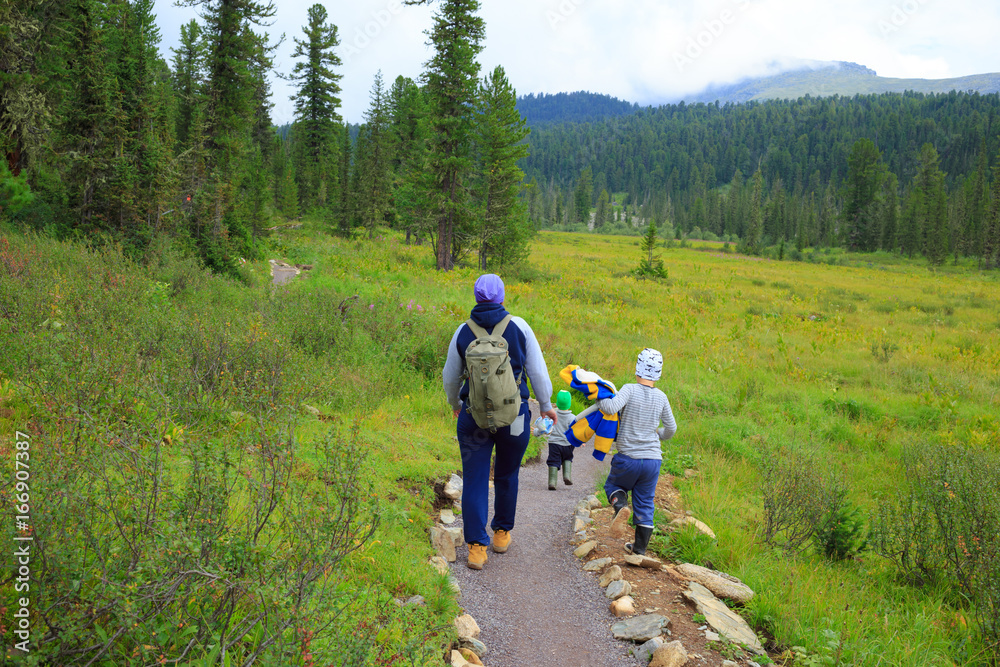 Hiking family in the siberian mountain forest