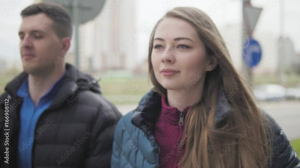 Young man and woman are walking down the street Young man and woman are walking down the street