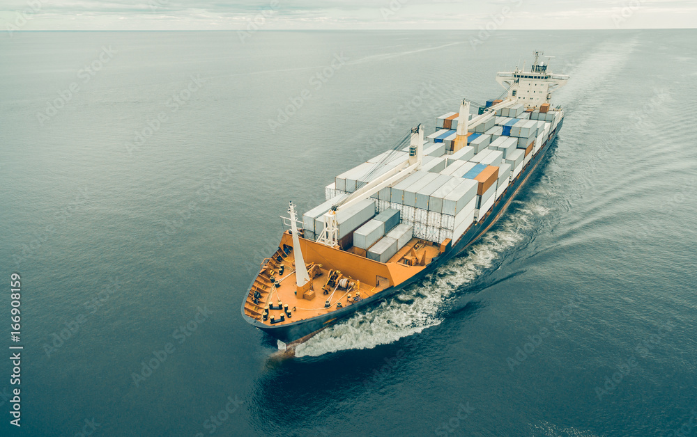 Aerial view of cargo ship sailing in open sea