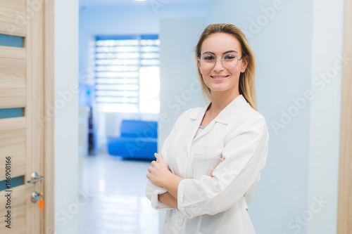 smiling medical doctor woman standing at hospital hall