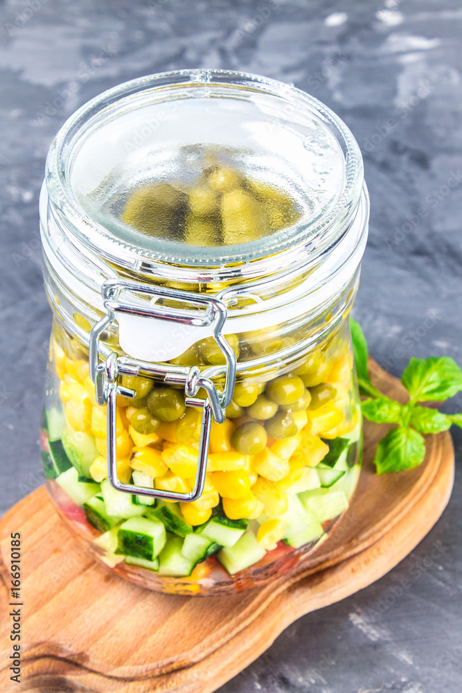 Healthy homemade salad in a jar with vegetables, cucumbers, tomatoes, peas and corn - Healthy diet, detox, pure food or vegetarian concept Healthy homemade salad in a jar with vegetables, cucumbers, tomatoes, peas and corn - Healthy diet, detox, pure food or vegetarian concept