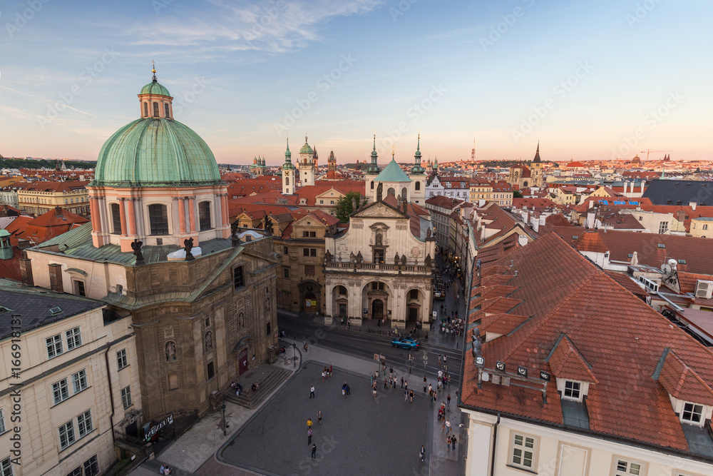 View of a square, St. Francis of Assissi Church and towers and other old buildings at the Old Town in Prague, Czech Republic, in the early evening from above.