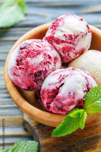Vanilla ice cream with currants in wooden bowl.