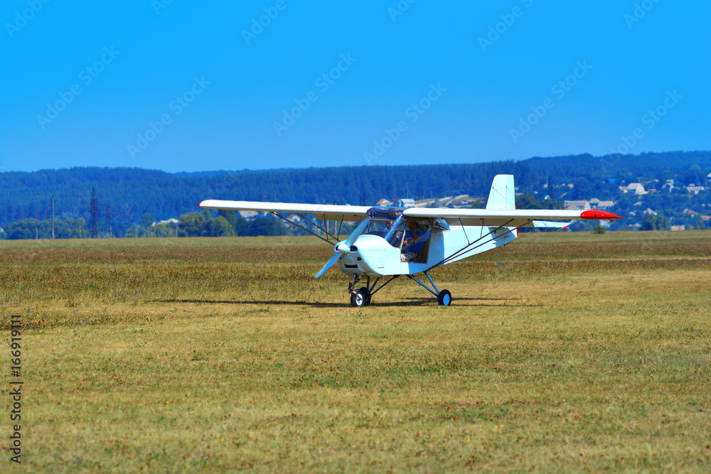A small white plane landed on the airfield A small white plane landed on the airfield