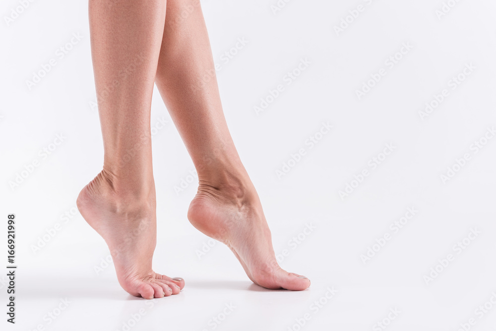 Youthful slim girl legs on white background