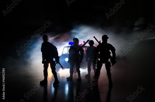 Anti-riot police give signal to be ready. Government power concept. Police in action. Smoke on a dark background with lights. Blue red flashing sirens. Dictatorship power.