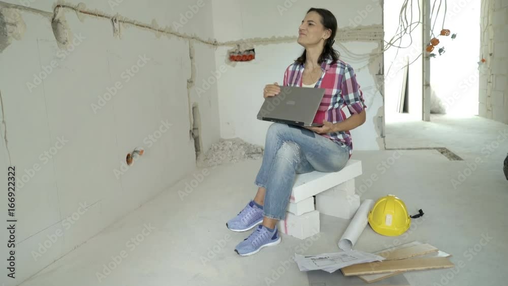 Satisfied woman sitting on the blocks and finish working on laptop, steadycam shot
