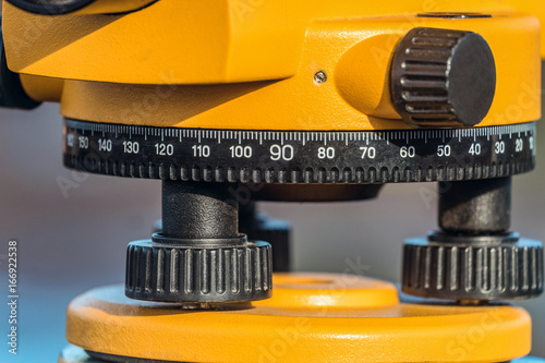Adjusting rings and scale of geodetic optical level close-up. Construction engineering equipment with limited depth of field.